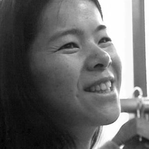 Photo en noir et blanc de Makiko Futaki, une femme souriante, vue de trois quart