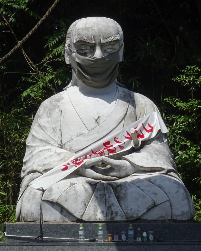 Grande sculpture en pierre représentant Musashi assis en posture zazen.