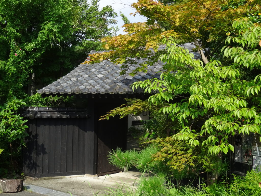 Entrée du musée Shimada : partail traditionnel derrière des arbres