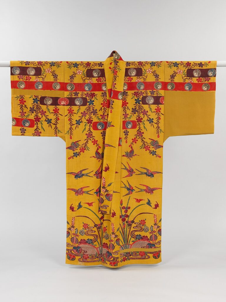 Un kimono traditionnel d'Okinawa jaune avec des motifs floraux rouges et bruns