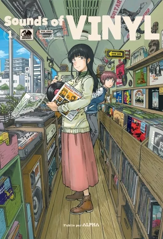 Une femme aux longs cheveux noirs se tient devant une platine disque, un vinyle dans les mains, une autre femme portant un blouson arrive derrière elle Elles sont entourées de disques