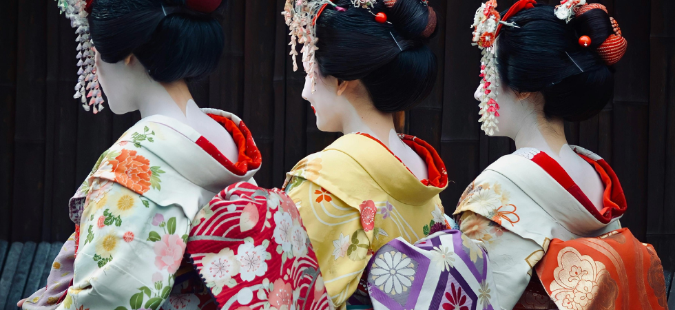 Trois Geisha de dos portant des kimonos et le maquillage traditionnel au Japon 