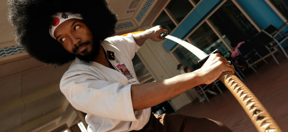 Cosplay d'un homme habillé en samouraï ayant une coupe de cheveux afro
