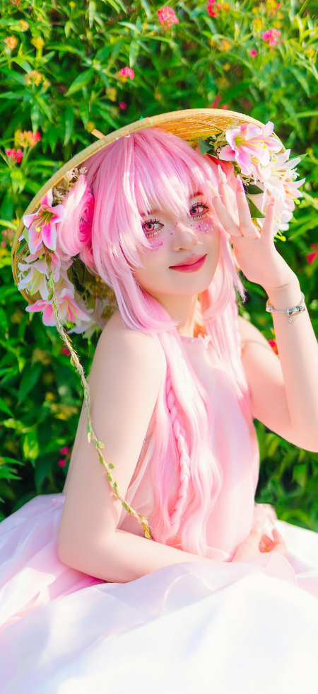 Portrait fantaisie femme aux cheveux roses portant un chapeau fleuri en extérieur