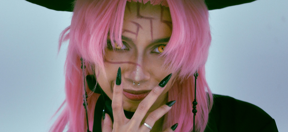 Cosplay de Romance Saja de Kpop Demon Hunters. Photo d'une femme ayant les cheveux roses, les yeux jaunes et les ongles noirs et longs.