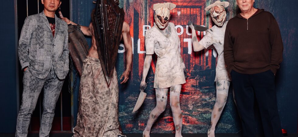 Akira Yamaoka Christophe gans pyramide hea et les infirmières, monstres mythiques du jeu silent hill posant devant l'affiche du film