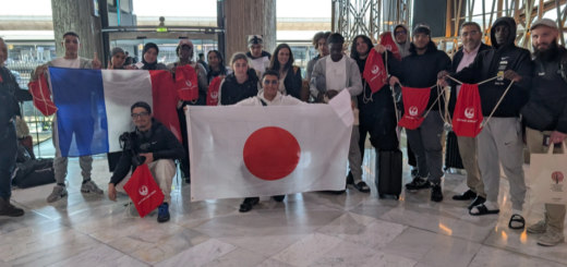 Un groupe d'une vingtaine de personnes portent deux grands drapeaux français et japonais.